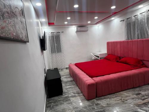 ein Schlafzimmer mit einem roten Sofa in einem Zimmer in der Unterkunft Acogedor y moderno Spot para parejas! in Pantoja