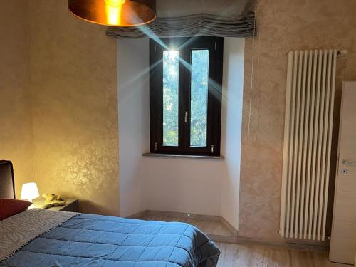 a bedroom with a blue bed and a window at Wave Home 2 in Castel Gandolfo