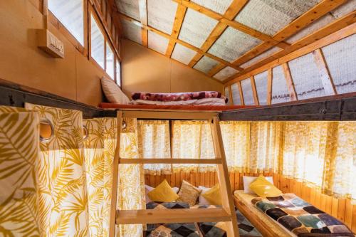 two bunk beds in a room with windows at Kanasar Jungle Camp & Retreat in Dehradun