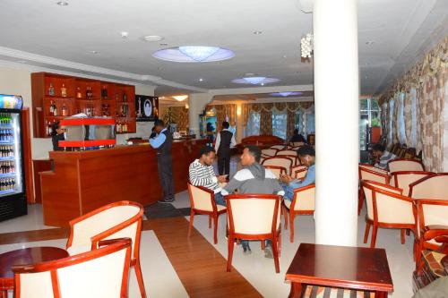 un grupo de personas sentadas en un restaurante en Yaredzema International Hotel, en Āksum