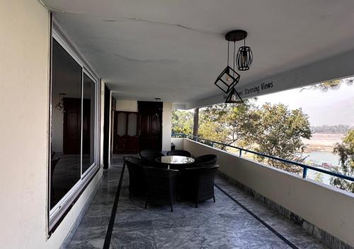 a balcony of a house with a table and chairs at PINETOP RESORT in Khanpur
