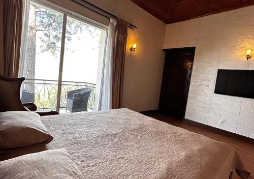 a bedroom with a bed and a large window at PINETOP RESORT in Khānpur