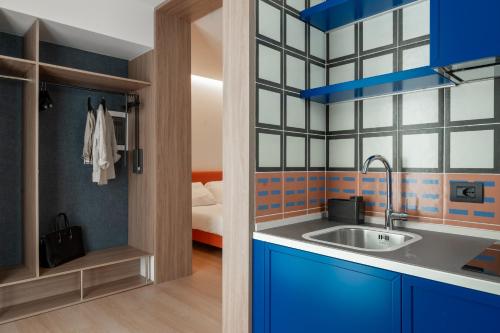 uma cozinha com armários azuis e um lavatório em Hotel Ungheria Varese 1946 em Varese