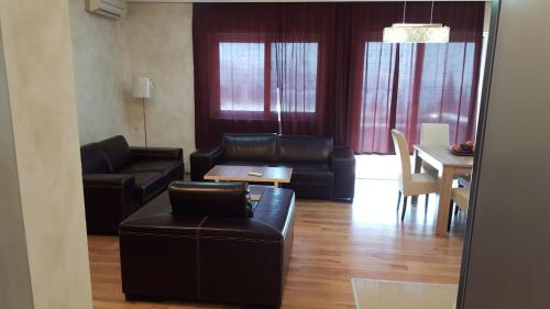 a living room with leather furniture and a dining room at Holiday Home Kalicanin in Bar