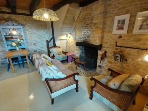 a living room with couches and a stone fireplace at Les Bernardies in Simeyrols