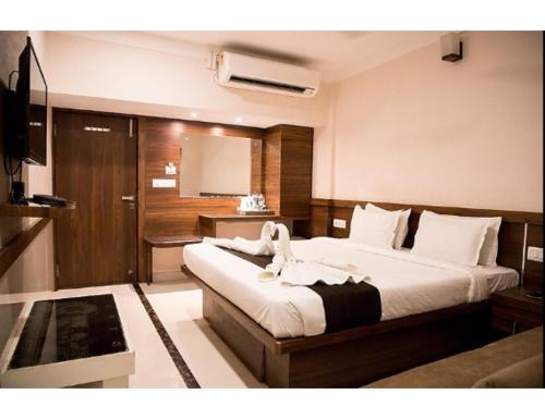 1 dormitorio con 1 cama grande y TV en Hotel Paras, Jabalpur, en Jabalpur