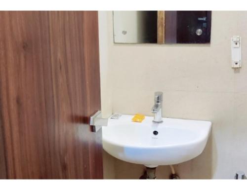 lavabo blanco en el baño con espejo en Hotel Paras, Jabalpur, en Jabalpur