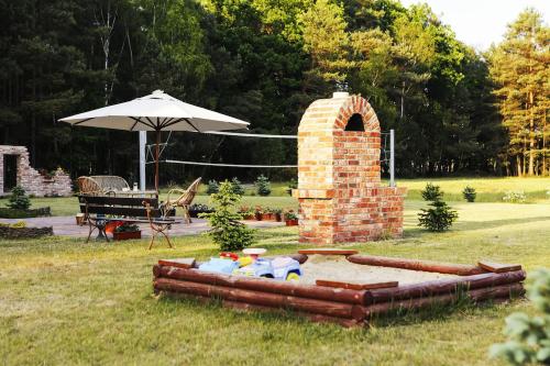 a brick fireplace in a yard with an umbrella at Bednarzówka in Nowy Tomyśl