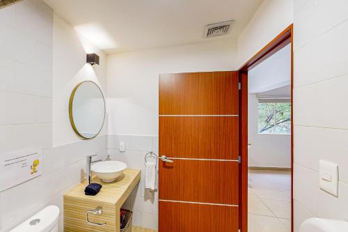 a bathroom with a wooden door and a sink at Cadetes 47 #201 in Mexico City