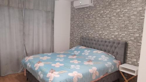 una camera da letto con un letto con copriletto blu e fiori di Apartman URBAN -1floor a Brčko
