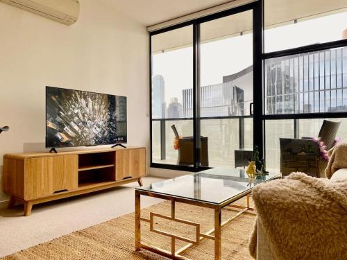 a living room with a couch and a glass table at Lovely 1BR Apartment - Free Parking in Melbourne