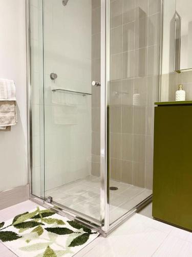 a shower with a glass door in a bathroom at Lovely 1BR Apartment - Free Parking in Melbourne