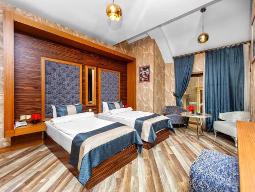 une chambre d'hôtel avec deux lits et un canapé dans l'établissement Manor Luxury Hotel Baku, à Baku