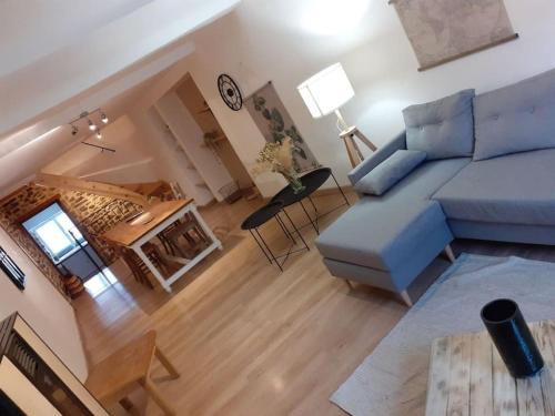 un salon avec un canapé bleu et une table dans l'établissement Agréable maison de village avec piscine, à Saint-Hilaire-de-Brethmas