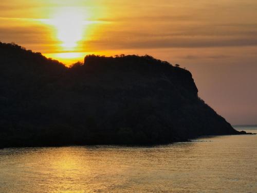 an island in the ocean at sunset at Myamo Beach Lodge in Jereweh