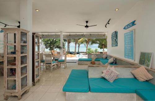 a living room with blue couches and a view of the ocean at Myamo Beach Lodge in Jereweh