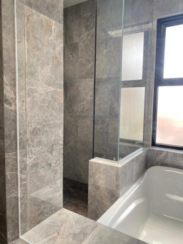 a bathroom with a bath tub and a window at Moniere House in Kasri