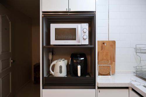 a microwave oven sitting on top of a kitchen cabinet at Stay Yeobaek,2BR,1BA,홍대2분,상수역5분,감성한옥,wifi,마포,스테이여백 in Seoul