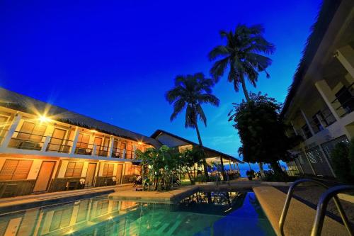 hotel z basenem w nocy w obiekcie Lalaguna Beach Club & Dive Centre w mieście Puerto Galera
