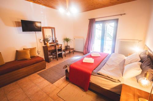 una camera da letto con un grande letto con una coperta rossa di Mountain Hotels "Aroanides" a Planitéron