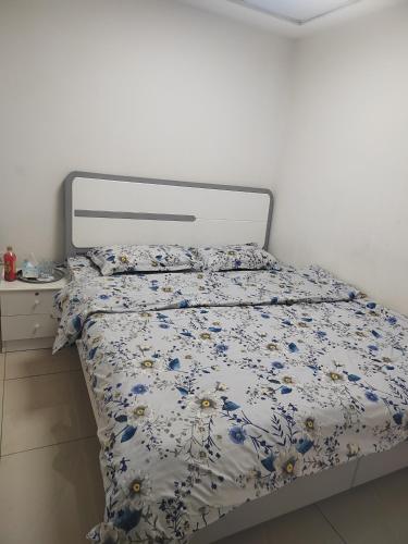 a bed with a floral comforter on it in a bedroom at 雅轩民宿 in Dubai