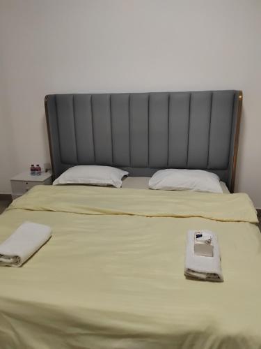a bed with a black headboard and two towels on it at 雅轩民宿 in Dubai