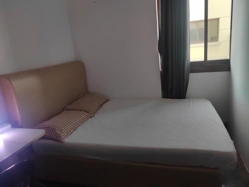 a small bed in a small room with a window at 雅轩民宿 in Dubai