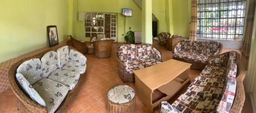uma grande sala de estar com sofás e uma mesa em TAPHE GUEST RESORT em Naivasha