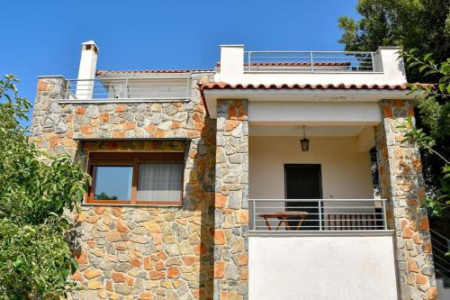 a stone house with a balcony on the side of it at Forest View House Seta in Séta