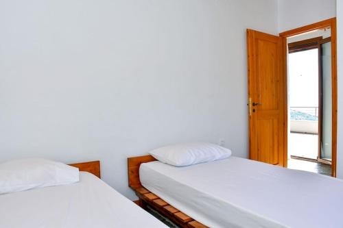 two beds in a room with a window at Forest View House Seta in Séta