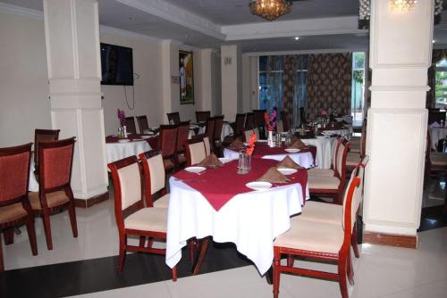 a dining room with tables and chairs in a restaurant at Yaredzema International Hotel in Āksum