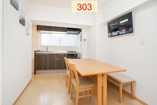 a small kitchen with a wooden table and chairs at Downtown Apartment/ SHIBUYA Station 10mins on foot in Tokyo