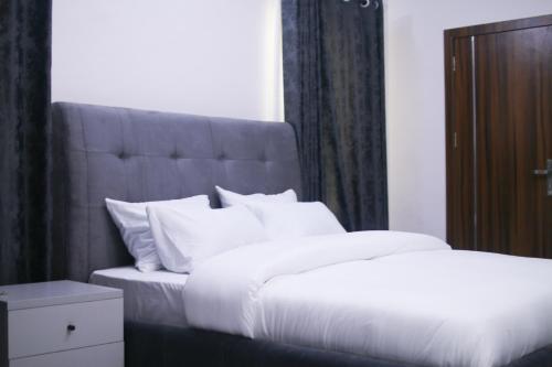 a bedroom with a large bed with white pillows at Victoria Homes - Lekki Apartment Lekki Phase 1 in Lekki