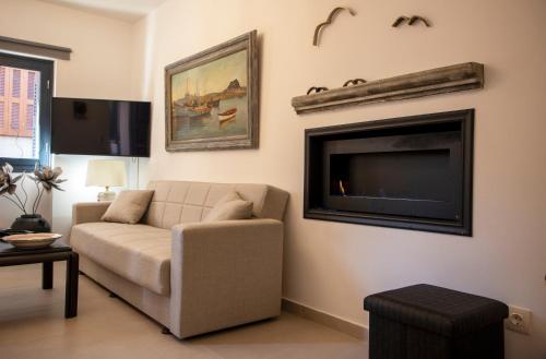 a living room with a couch and a flat screen tv at Simo's Apartments in Egina