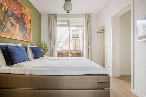 1 dormitorio con 1 cama grande con almohadas azules en Stroll the waterfront from a Harbour-Site app, en La Haya