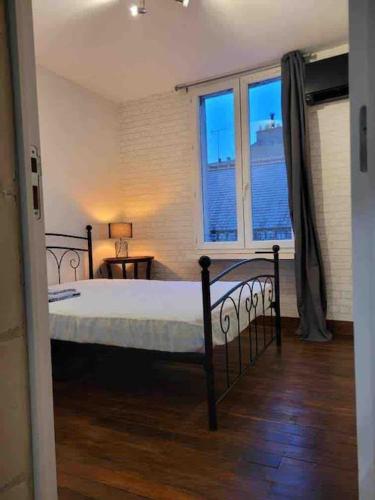 1 dormitorio con cama y ventana en Appartement calme et chaleureux, en Tours