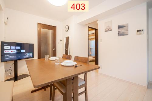 a dining room with a table and a tv at Downtown Apartment/ SHIBUYA Station 10mins on foot in Tokyo