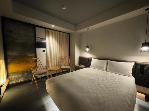 大阪市にあるホテルリソルトリニティ大阪のベッドルーム1室(ベッド1台、椅子2脚付)