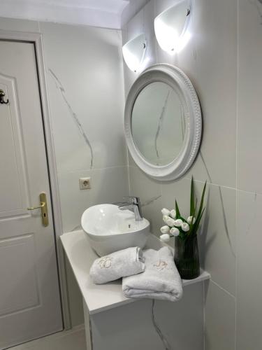 a bathroom with a sink and a mirror and towels at Neptune family Villa in Zakynthos Town