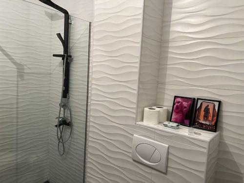 a white bathroom with a shower and a mirror at Pejton's Hidden Gem: 94squares in City Center in Pristina