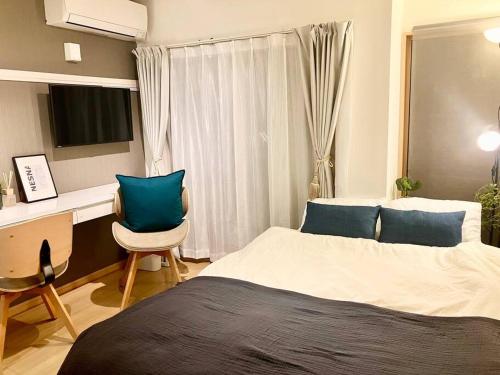 ein Schlafzimmer mit einem Bett, einem Schreibtisch und einem Computer in der Unterkunft AYA Funabashi102 船橋駅徒歩7分 観光地へアクセス良好 空港直通 買物と飲食天国 ディズニー 長期 カップル 1人 出張 bidet seat in Funabashi