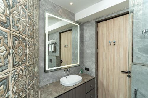 ein Bad mit einem Waschbecken und einem Spiegel in der Unterkunft Lotus Villa Goa in Mandrem