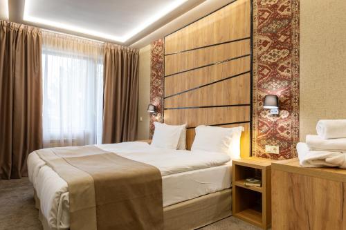 a hotel room with a large bed and a window at SPA Hotel Olymp in Velingrad