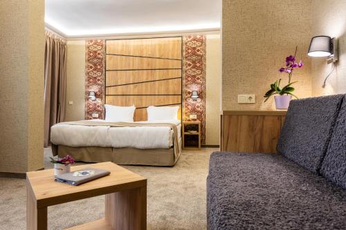 a hotel room with a bed and a couch at SPA Hotel Olymp in Velingrad