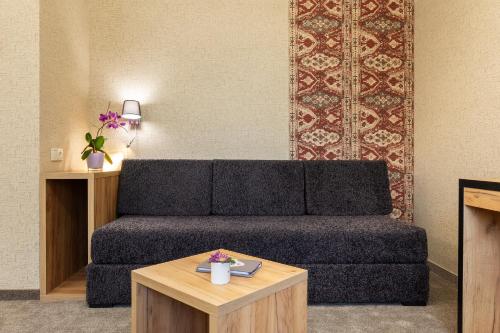 a living room with a couch and a coffee table at SPA Hotel Olymp in Velingrad