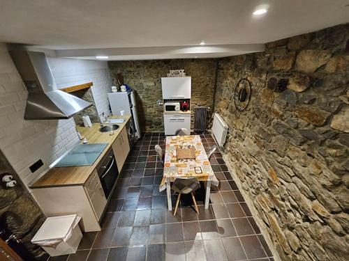 cocina con mesa y pared de piedra en Casita con encanto, en Collanzo