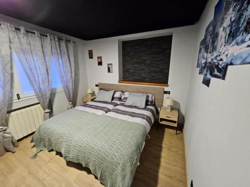 a bedroom with a large bed and two windows at Casita con encanto, les gaites in Collanzo