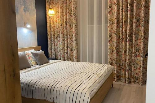 um quarto com uma cama num quarto com cortinas em Apartament Niebieski em Lódź
