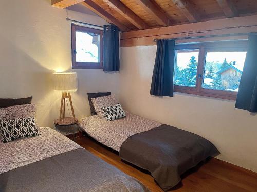 a bedroom with two beds and a window at Arc 1800, le Chalet Manaro avec sa vue panoramique in Bourg-Saint-Maurice