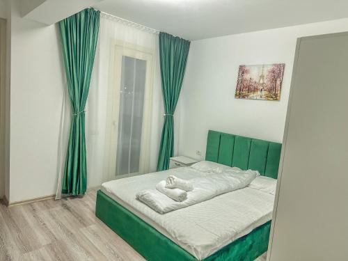 a bedroom with a bed with green curtains and a mirror at Luxury Bucovina in Gura Humorului